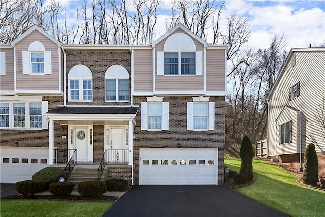 view of front of property with driveway, an attached garage, and brick siding