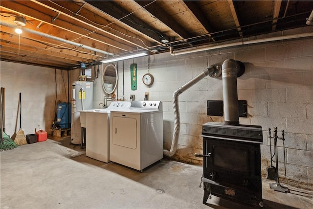 unfinished below grade area featuring a wood stove, separate washer and dryer, and electric water heater