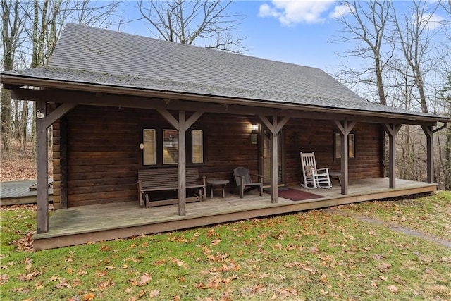 exterior space featuring a shingled roof and a yard