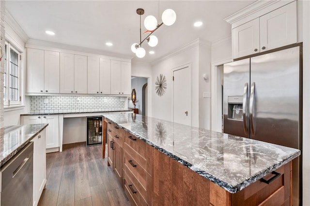 kitchen featuring dark wood-style floors, crown molding, appliances with stainless steel finishes, white cabinetry, and beverage cooler