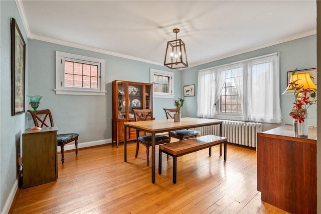 dining space featuring radiator heating unit, plenty of natural light, light wood-style flooring, and crown molding