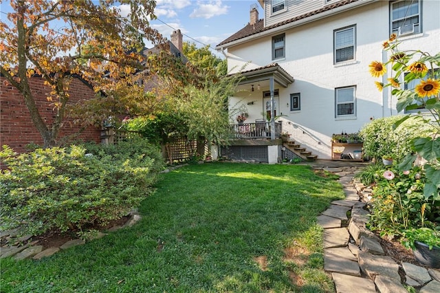 view of yard featuring fence and stairs