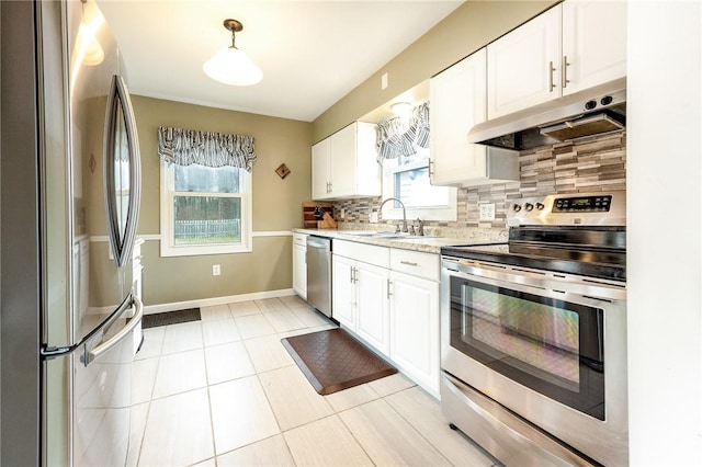 kitchen with under cabinet range hood, appliances with stainless steel finishes, white cabinets, and a sink