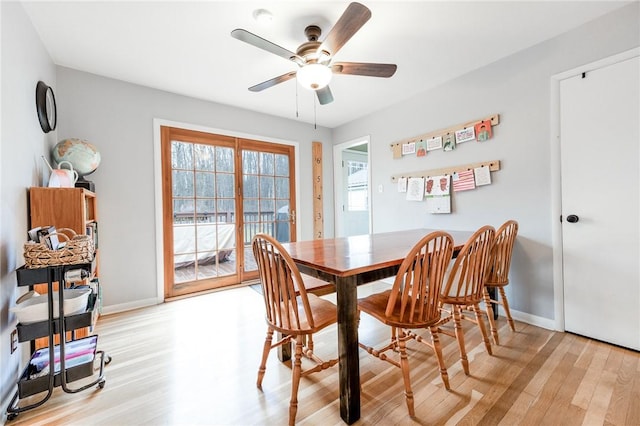 dining room featuring ceiling fan, baseboards, and light wood-style floors