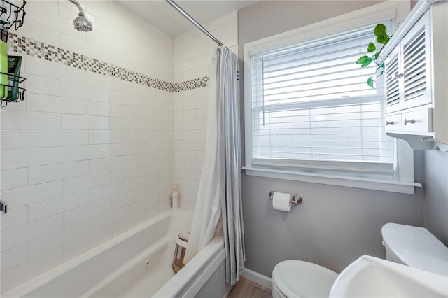 bathroom featuring baseboards, toilet, and shower / bath combo with shower curtain