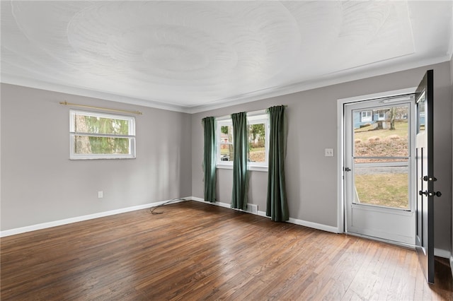 spare room featuring hardwood / wood-style floors, a wealth of natural light, and baseboards