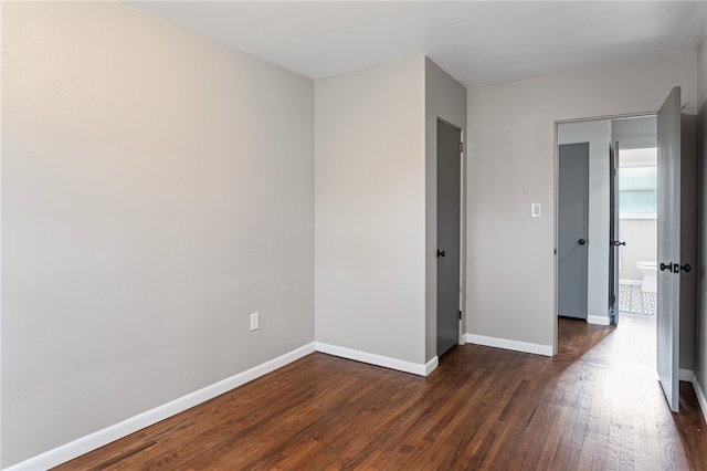 unfurnished bedroom featuring dark wood-type flooring and baseboards