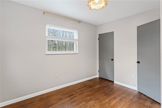 unfurnished bedroom with wood finished floors and baseboards