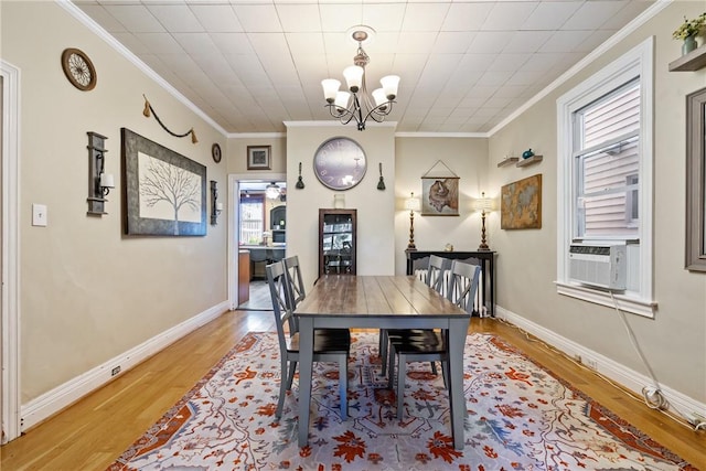 dining space featuring light wood-style floors, baseboards, ornamental molding, and cooling unit