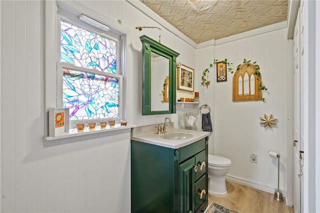 half bath featuring vanity, toilet, and wood finished floors