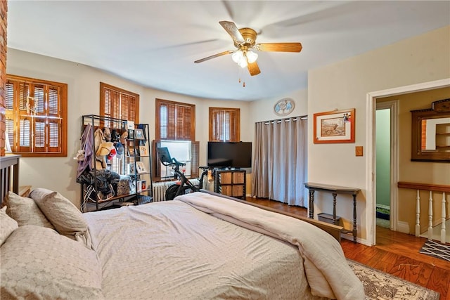 bedroom with wood finished floors, a ceiling fan, and baseboards