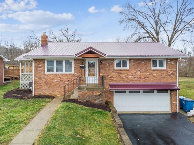 view of front of house with driveway, a chimney, metal roof, an attached garage, and brick siding