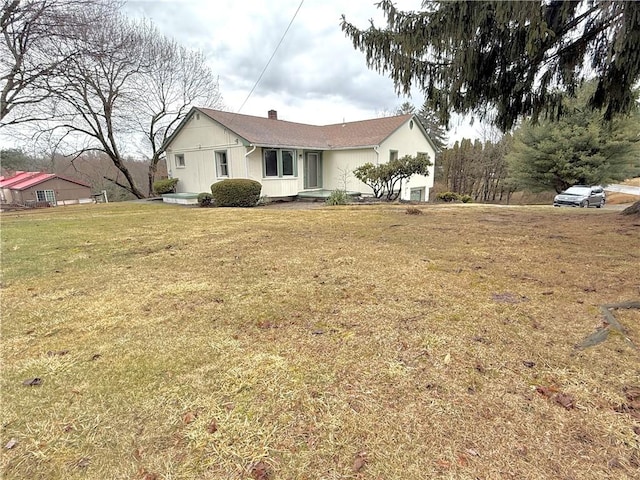 view of home's exterior featuring a lawn and a chimney