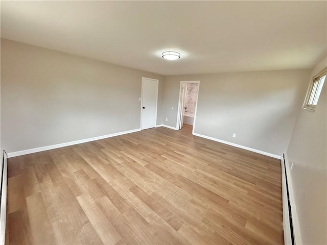 empty room featuring light wood-type flooring and baseboards