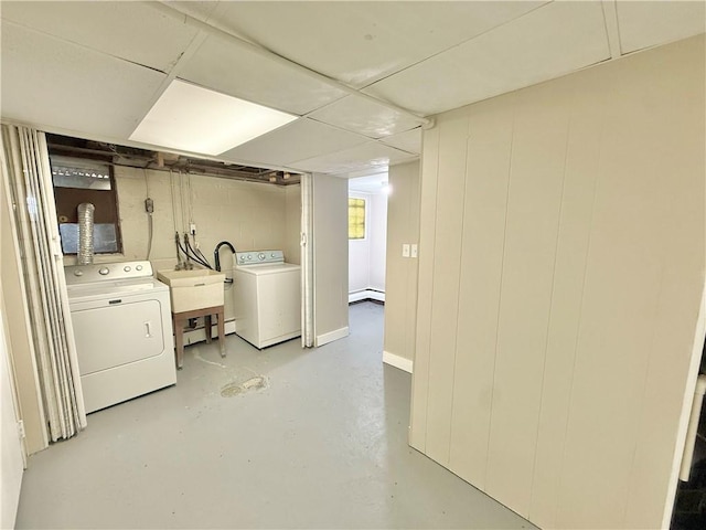 laundry area featuring laundry area, separate washer and dryer, baseboard heating, and a sink