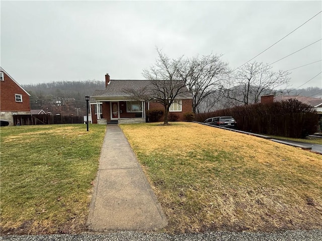 bungalow-style home featuring a porch, a front yard, and brick siding