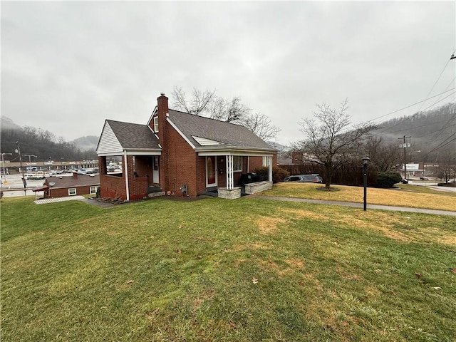 view of home's exterior featuring roof with shingles, a chimney, a lawn, and brick siding