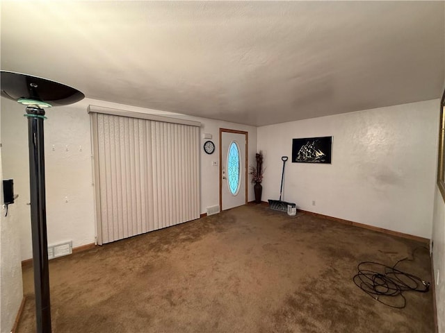 basement with baseboards, visible vents, and carpet flooring