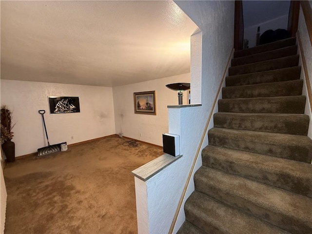 stairway featuring carpet, baseboards, and a textured wall