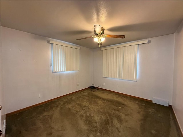 empty room featuring ceiling fan, carpet flooring, visible vents, and baseboards