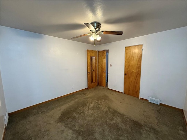 carpeted empty room with ceiling fan, visible vents, and baseboards