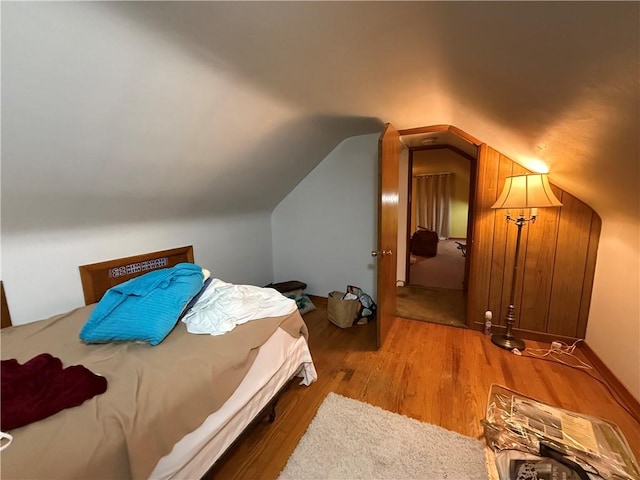 bedroom featuring lofted ceiling and wood finished floors