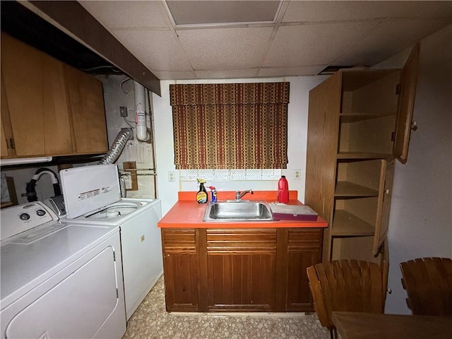 laundry room featuring washer and clothes dryer, a sink, and cabinet space