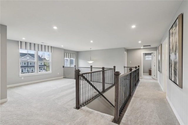 corridor featuring an upstairs landing, recessed lighting, baseboards, and light colored carpet