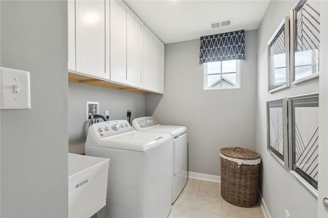 clothes washing area with a sink, visible vents, baseboards, cabinet space, and washing machine and clothes dryer