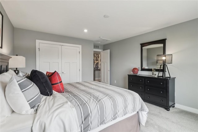 bedroom featuring a closet, visible vents, attic access, light carpet, and baseboards