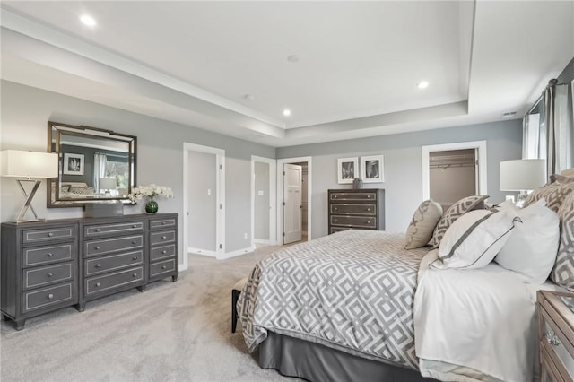 bedroom featuring recessed lighting, a raised ceiling, light carpet, and baseboards