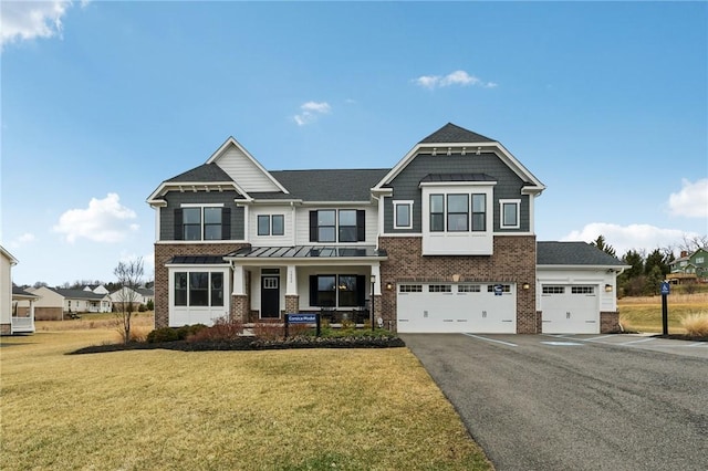 view of front of house with an attached garage, brick siding, driveway, and a front lawn