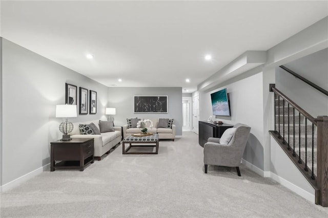 living area featuring recessed lighting, light carpet, stairway, and baseboards