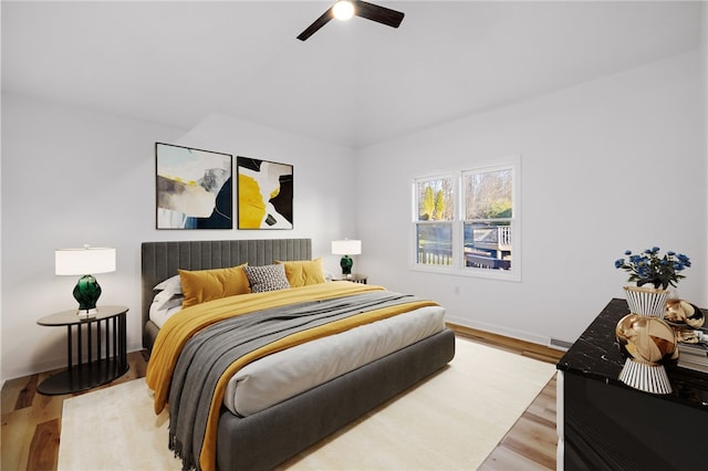 bedroom with ceiling fan, baseboards, and wood finished floors