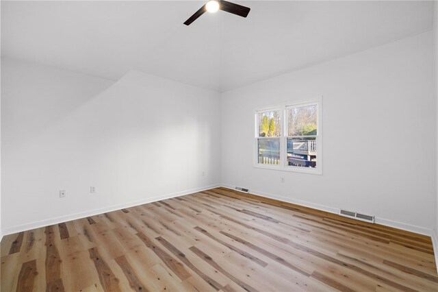 empty room featuring visible vents, ceiling fan, light wood-style flooring, and baseboards