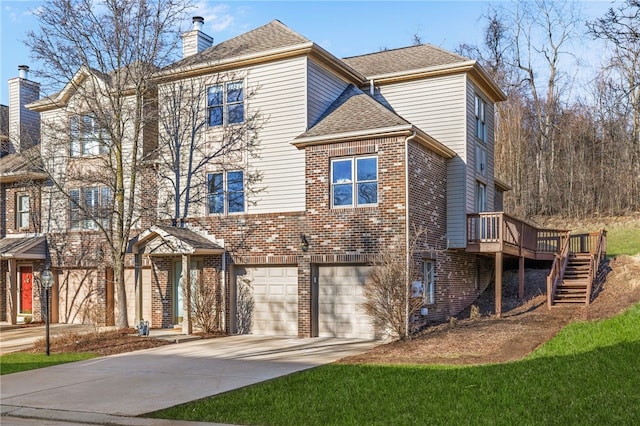 view of front of home featuring concrete driveway, a chimney, stairway, roof with shingles, and brick siding