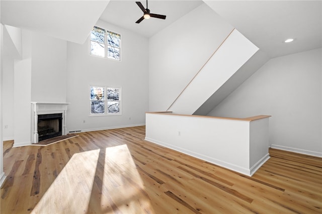 unfurnished living room with a fireplace, recessed lighting, a ceiling fan, wood finished floors, and baseboards