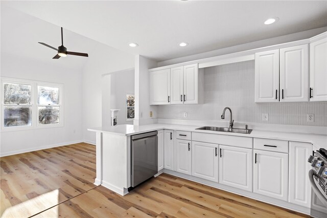 kitchen featuring a peninsula, white cabinetry, appliances with stainless steel finishes, and a sink