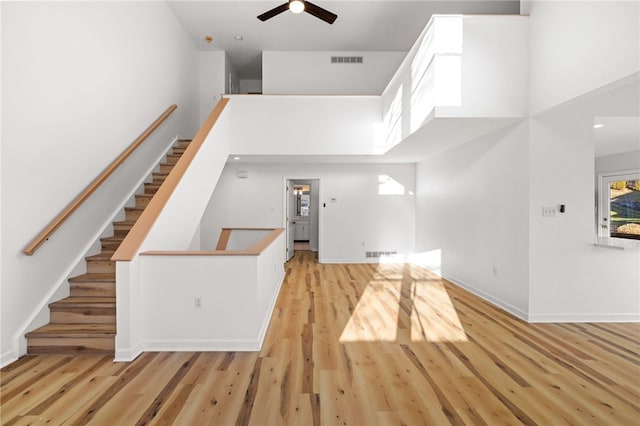 foyer entrance featuring a towering ceiling, visible vents, and wood finished floors