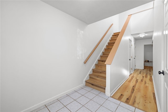 stairs with baseboards and tile patterned floors