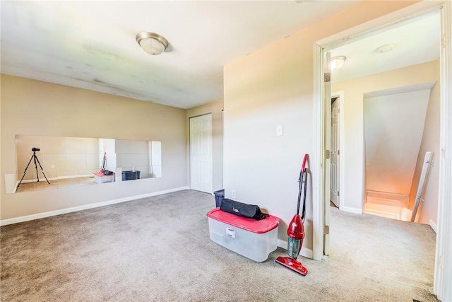 misc room with carpet flooring and baseboards