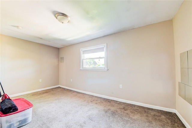 unfurnished room featuring carpet and baseboards