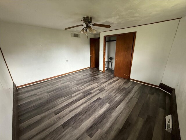 705 E 18th Ave, Munhall, PA 15120 - unfurnished bedroom with dark wood finished floors, baseboards, a ceiling fan, and a closet