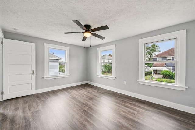 spare room with dark wood finished floors, ceiling fan, and baseboards