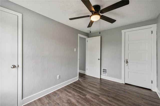 unfurnished bedroom with visible vents, a textured ceiling, baseboards, and wood finished floors