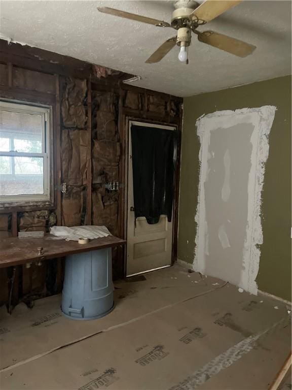 misc room with ceiling fan and a textured ceiling