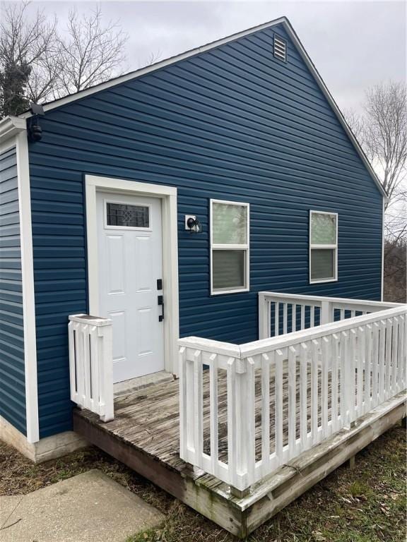 rear view of house featuring a wooden deck