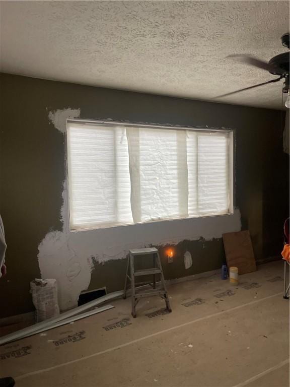 interior space with a ceiling fan and a textured ceiling