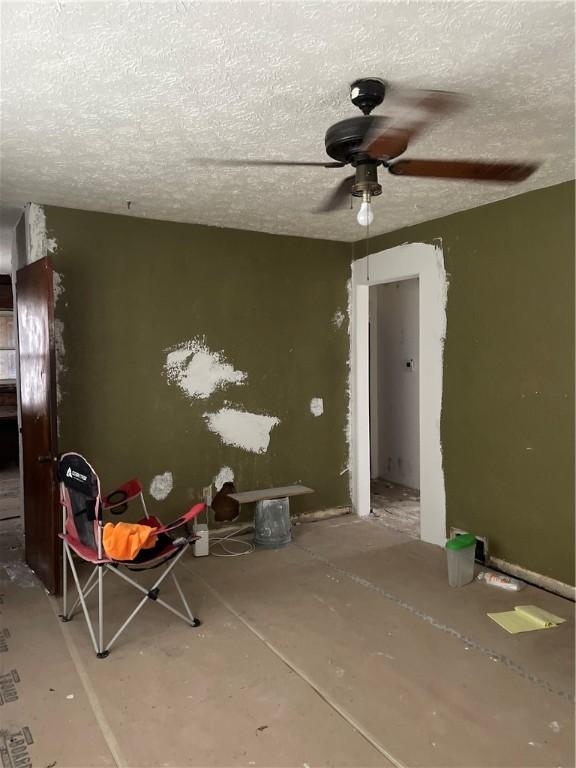 spare room featuring a ceiling fan, concrete flooring, and a textured ceiling