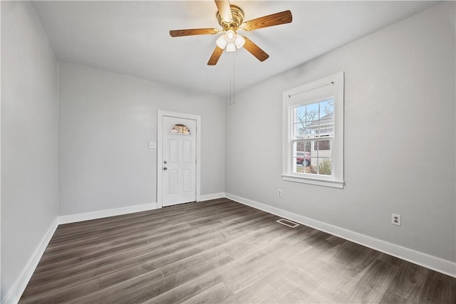 unfurnished room featuring visible vents, ceiling fan, baseboards, and wood finished floors